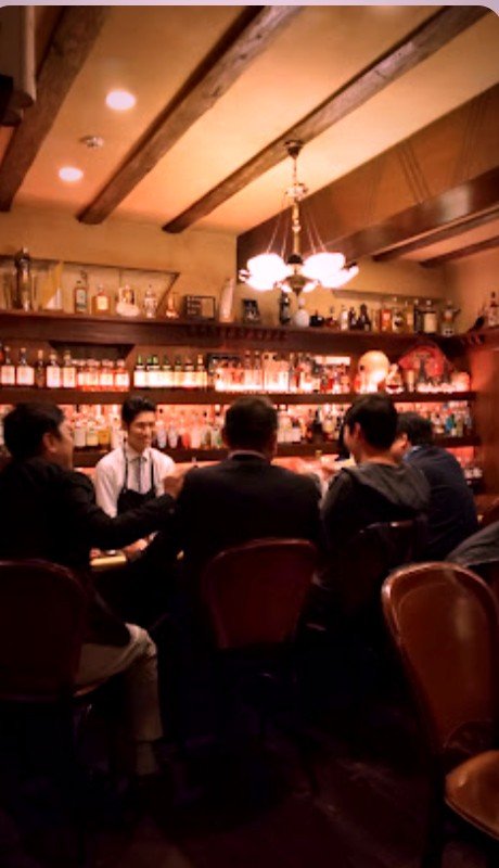 Guests at the wooden counter with the bartender